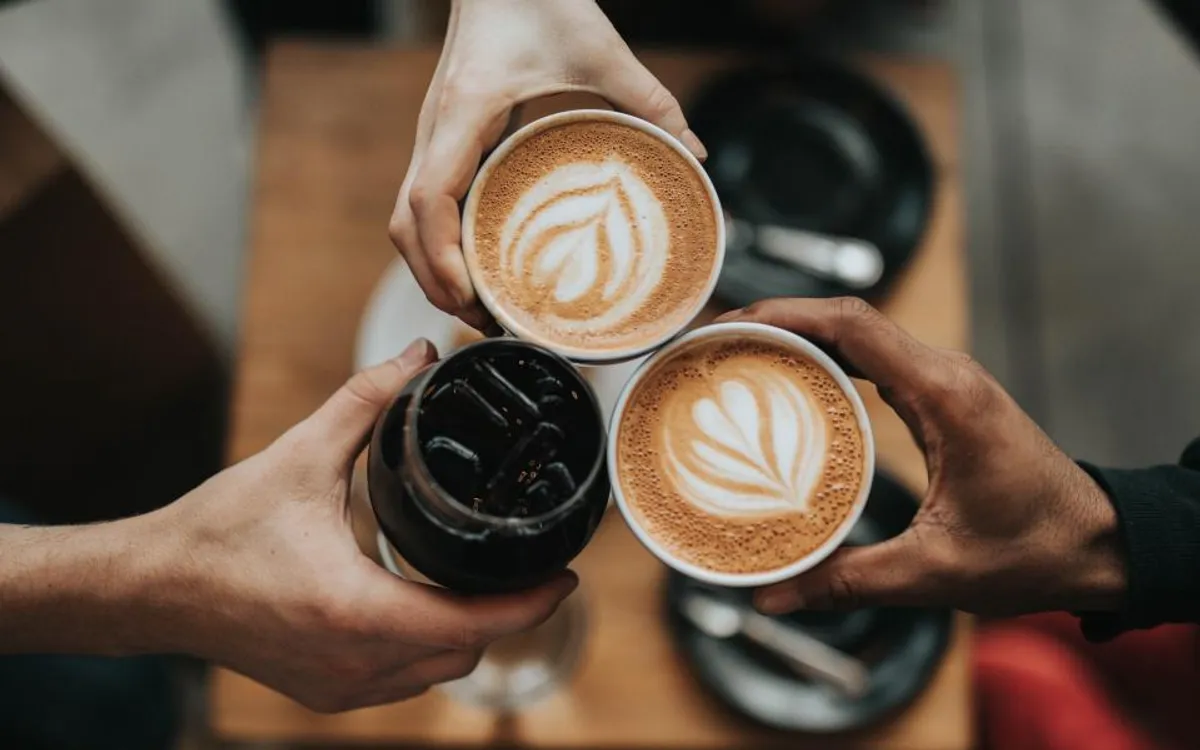 Three friends clinking coffee cups