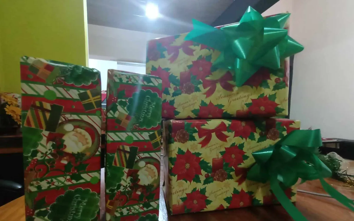 Wrapped Christmas presents with green bows on a table