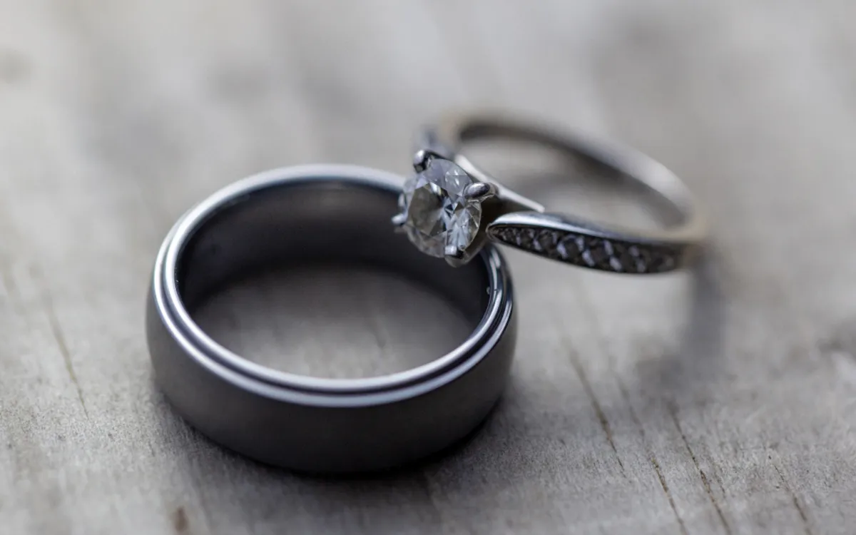 Two wedding bands and an engagement ring on wood